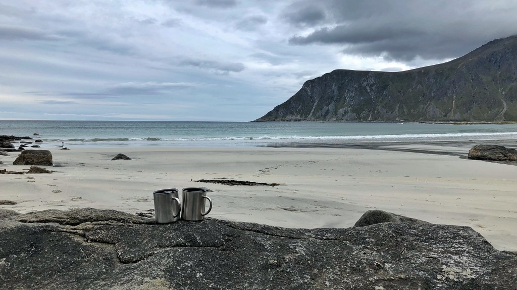 Beach scene with two mugs in the foreground