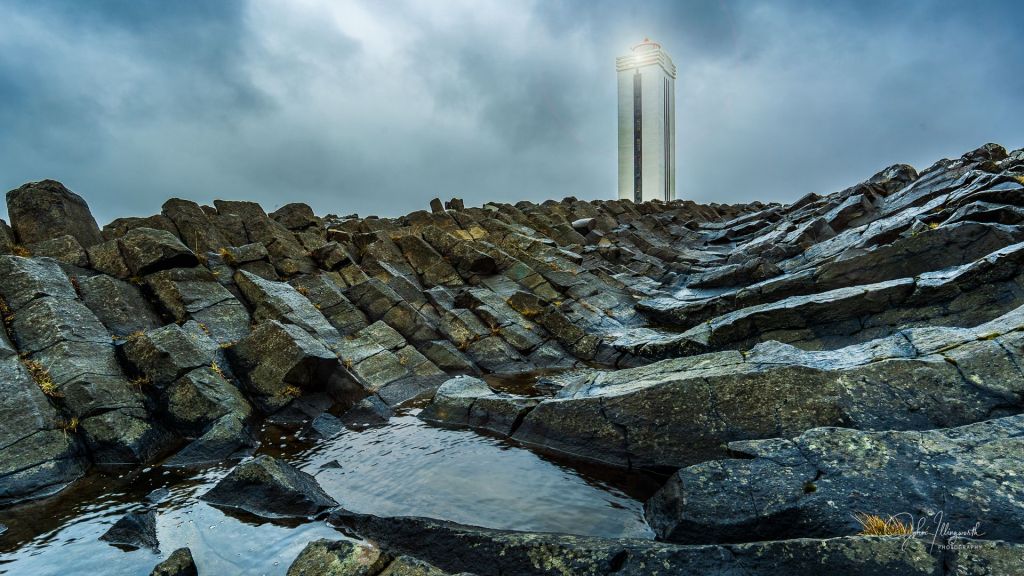 Picture of a lighthouse with rocks in the foreground.
